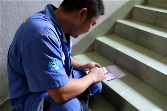 客戶還是沒有到，家具安裝謝師傅蹲在門口等，一邊等一邊處理今天要去的下一家客戶的資料