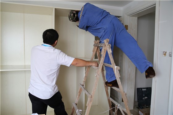 左右手家具安裝師傅彼此合作，完成家具安裝工作