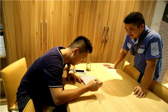 左右手安裝師傅在和客戶填寫(xiě)衣柜安裝信息反饋